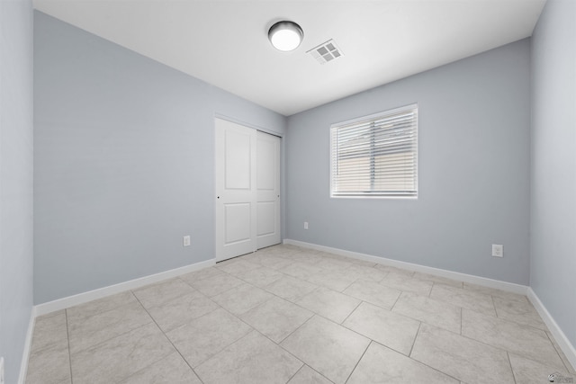 10858 E 45th Ln, Yuma, AZ 85367 - unfurnished bedroom with baseboards, a closet, and light tile patterned floors
