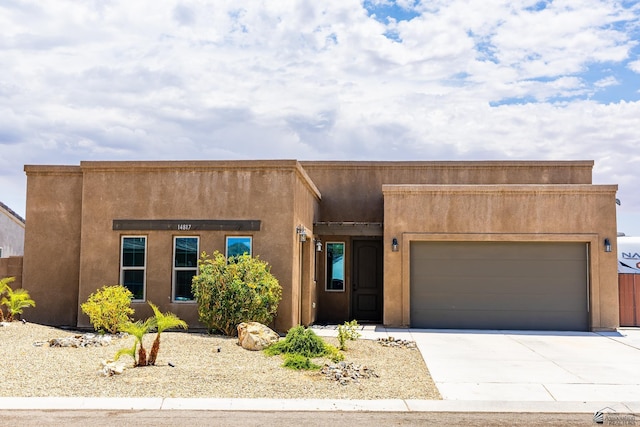 14817 E 47th Dr, Yuma, AZ 85367 - pueblo-style house featuring driveway, a garage, and stucco siding