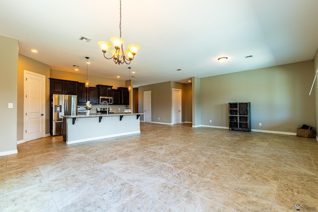 14817 E 47th Dr, Yuma, AZ 85367 - kitchen featuring stainless steel appliances, a breakfast bar area, a chandelier, open floor plan, and a center island with sink