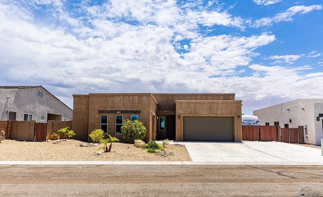 14817 E 47th Dr, Yuma, AZ 85367 - pueblo revival-style home with a garage, concrete driveway, stucco siding, and a gate
