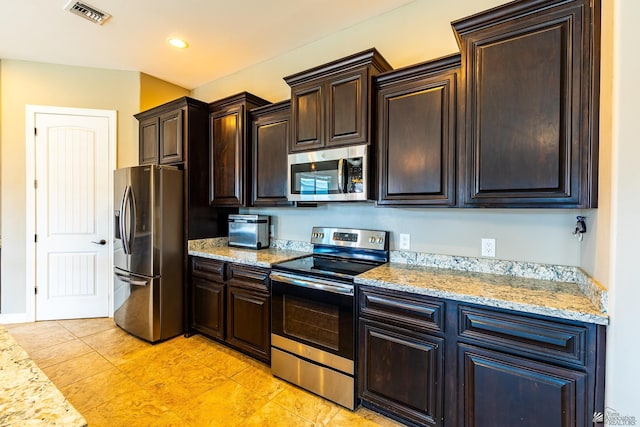 14817 E 47th Dr, Yuma, AZ 85367 - kitchen with stainless steel appliances, dark brown cabinets, light stone counters, and light tile patterned flooring