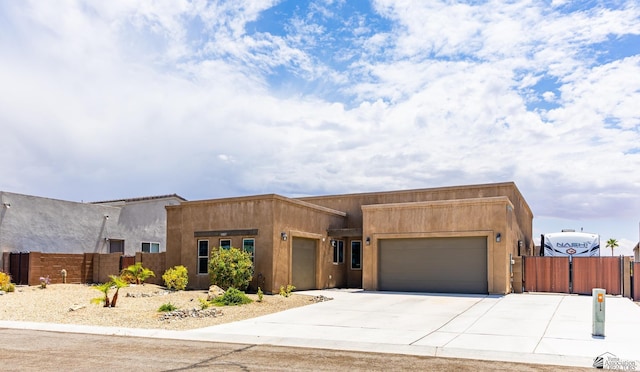 14817 E 47th Dr, Yuma, AZ 85367 - pueblo revival-style home featuring a garage, a gate, stucco siding, and concrete driveway
