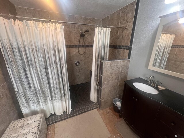 1911 S 11th Ave, Yuma, AZ 85364 - bathroom featuring tiled shower, vanity, and a textured ceiling