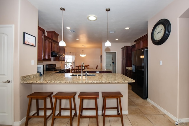 12127 E 35th St, Yuma, AZ 85367 - kitchen with a sink, a breakfast bar area, a peninsula, under cabinet range hood, and black appliances