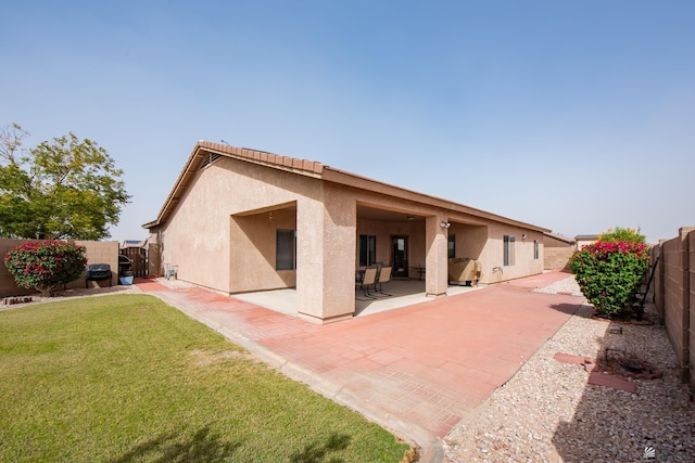 12127 E 35th St, Yuma, AZ 85367 - back of house with a fenced backyard, a patio, stucco siding, and a lawn