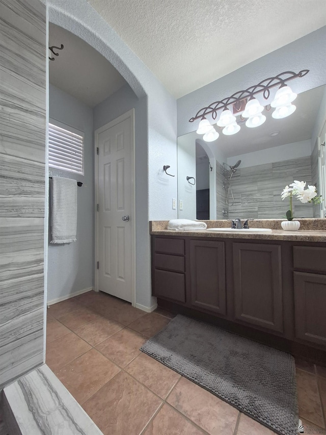10178 S Cony Ave, Yuma, AZ 85367 - bathroom with vanity, tile patterned flooring, a textured ceiling, baseboards, and tiled shower