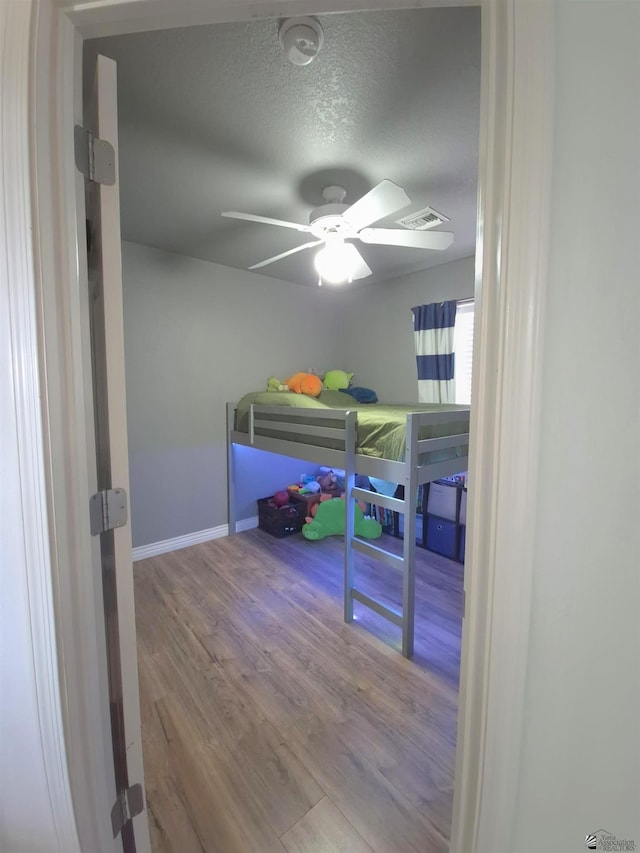 10178 S Cony Ave, Yuma, AZ 85367 - bedroom with wood finished floors, a textured ceiling, baseboards, and a ceiling fan