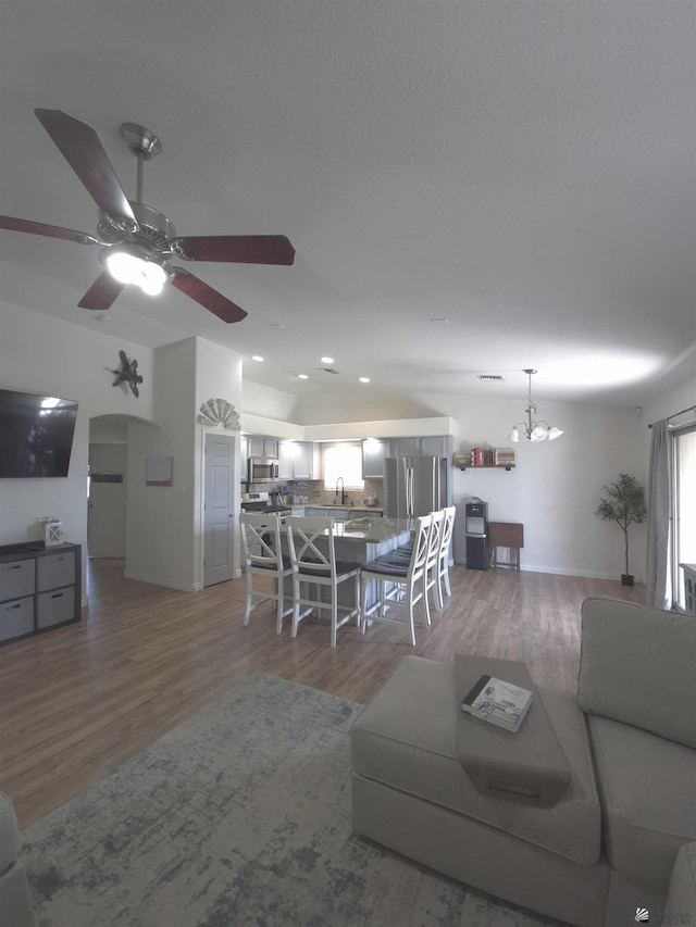 10178 S Cony Ave, Yuma, AZ 85367 - living area with light wood finished floors, ceiling fan, a chandelier, baseboards, and arched walkways