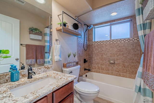 full bath with visible vents, shower / bath combo with shower curtain, vanity, toilet, and a textured ceiling