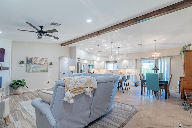 living area featuring visible vents, arched walkways, ceiling fan with notable chandelier, vaulted ceiling with beams, and recessed lighting