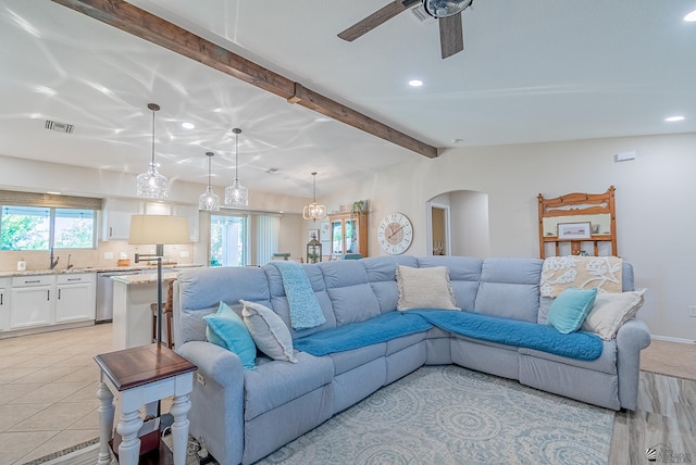 living area with a ceiling fan, visible vents, arched walkways, beamed ceiling, and recessed lighting