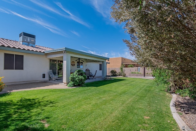 back of house with fence, a patio, stucco siding, a yard, and a tile roof
