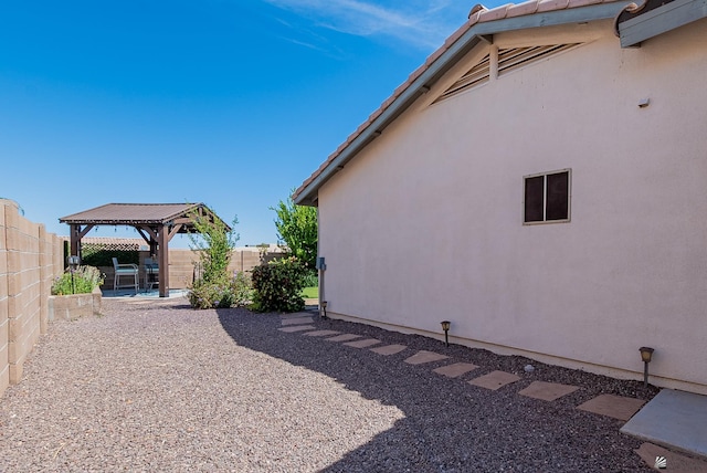 view of yard featuring a gazebo, a fenced backyard, and a patio area