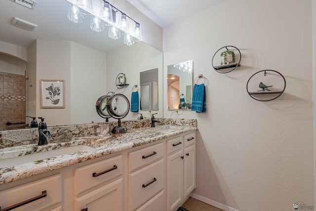 full bath with double vanity, visible vents, and a sink