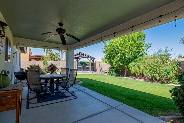view of patio / terrace featuring outdoor dining area, a ceiling fan, a gazebo, and a fenced backyard