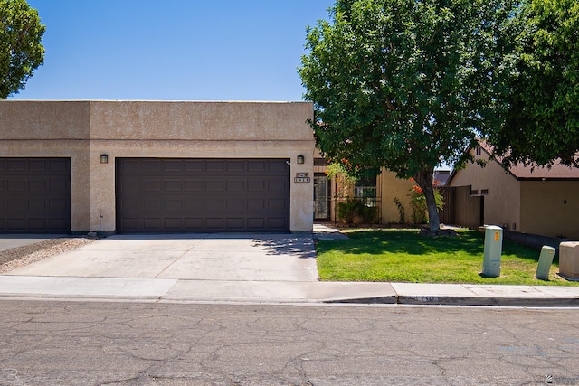 pueblo-style home with an attached garage, stucco siding, fence, concrete driveway, and a front lawn