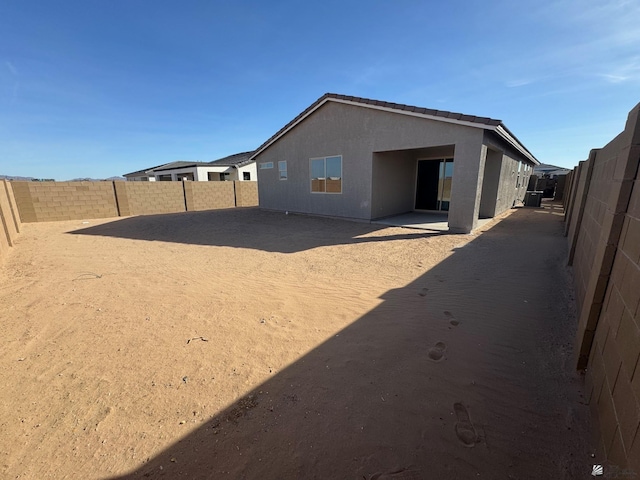 back of property with a fenced backyard and stucco siding