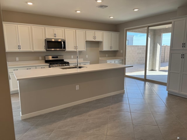 kitchen featuring a sink, a kitchen island with sink, stainless steel appliances, white cabinetry, and visible vents