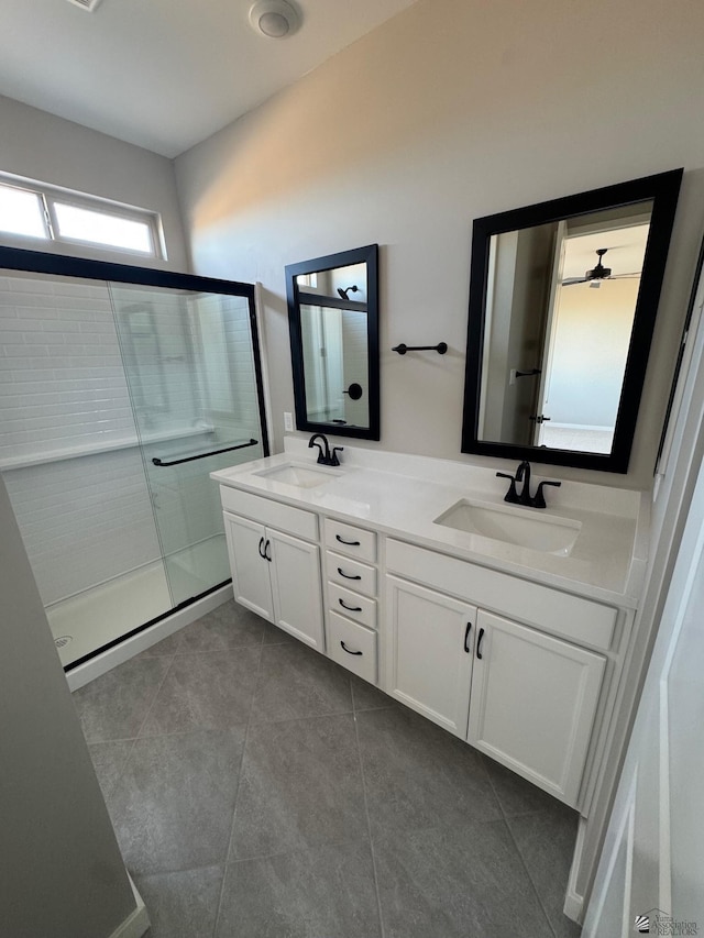 full bathroom featuring double vanity, a sink, tile patterned floors, and a shower stall