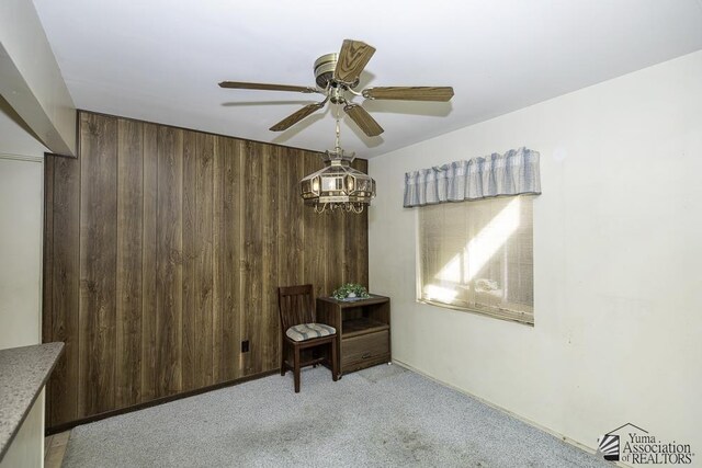 232 E 25th Pl, Yuma, AZ 85364 - dining space with a ceiling fan, wood walls, and light colored carpet