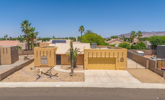 11212 E 37th Ln, Yuma, AZ 85367 - pueblo-style home with stucco siding, an attached garage, a mountain view, driveway, and a gate