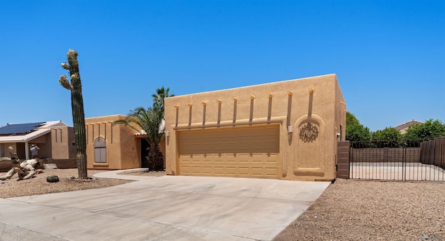 11212 E 37th Ln, Yuma, AZ 85367 - adobe home with a gate, an attached garage, concrete driveway, and stucco siding