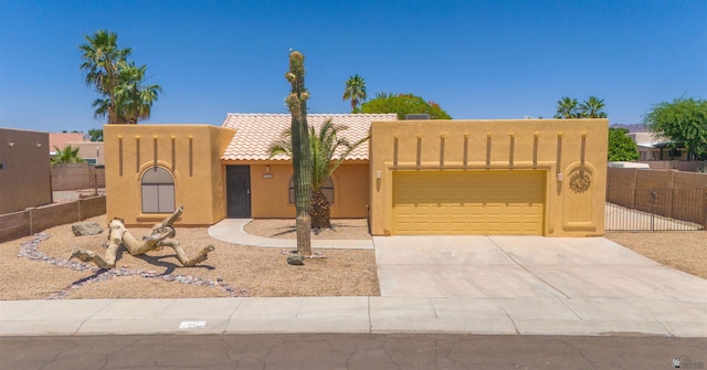 11212 E 37th Ln, Yuma, AZ 85367 - pueblo-style home featuring stucco siding, an attached garage, a tile roof, and concrete driveway