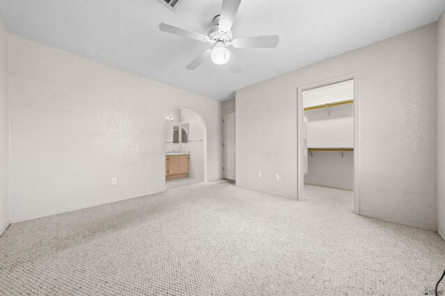 11212 E 37th Ln, Yuma, AZ 85367 - unfurnished bedroom featuring carpet, a spacious closet, a closet, arched walkways, and ceiling fan