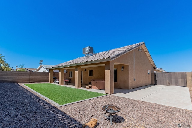 10237 S Monsoon Ave, Yuma, AZ 85365 - back of house featuring a hot tub, an outdoor fire pit, stucco siding, a fenced backyard, and a patio area