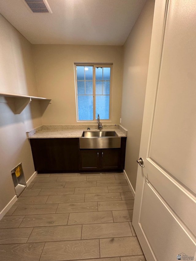 14701 E 42nd St, Yuma, AZ 85367 - laundry room with visible vents, wood finish floors, cabinet space, a sink, and baseboards