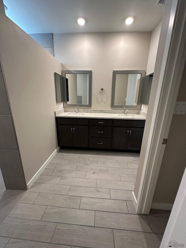 14701 E 42nd St, Yuma, AZ 85367 - full bathroom featuring double vanity, baseboards, wood finish floors, and a sink