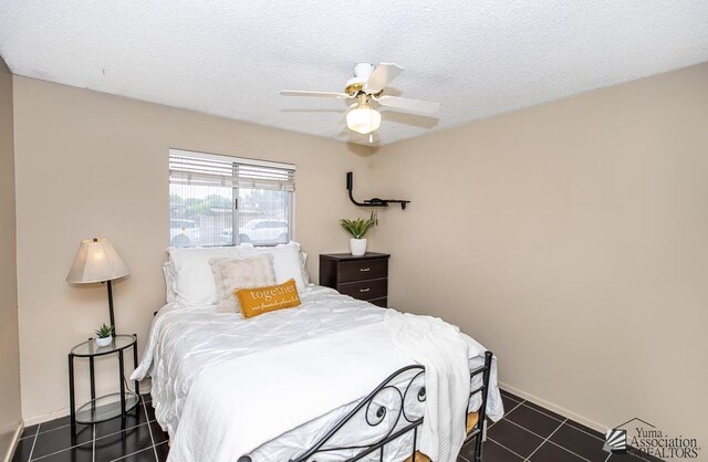 1878 S Meadowbrook Ave, Yuma, AZ 85364 - bedroom with dark tile patterned flooring, ceiling fan, baseboards, and a textured ceiling