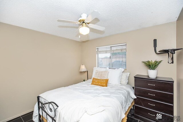 1878 S Meadowbrook Ave, Yuma, AZ 85364 - bedroom featuring a textured ceiling, ceiling fan, dark tile patterned floors, and baseboards