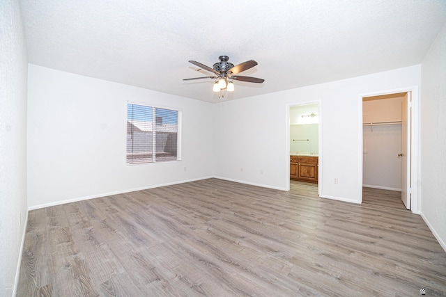 11250 E 25th Pl, Yuma, AZ 85367 - unfurnished bedroom featuring light wood-style floors, a spacious closet, baseboards, and a closet