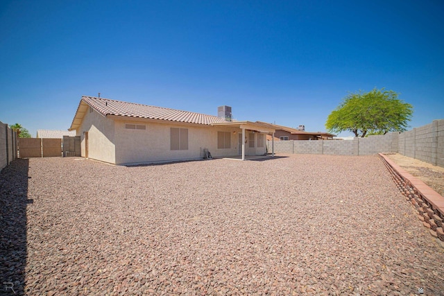11250 E 25th Pl, Yuma, AZ 85367 - back of house with stucco siding, a fenced backyard, a tiled roof, a chimney, and a patio
