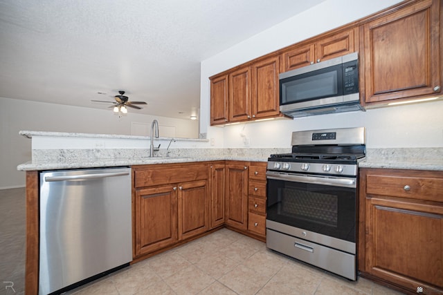 11250 E 25th Pl, Yuma, AZ 85367 - kitchen featuring appliances with stainless steel finishes, brown cabinets, a ceiling fan, a peninsula, and light tile patterned floors