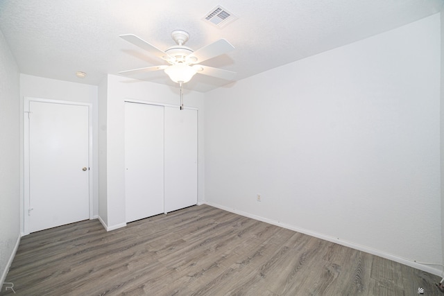 11250 E 25th Pl, Yuma, AZ 85367 - unfurnished bedroom with wood finished floors, a closet, baseboards, and ceiling fan