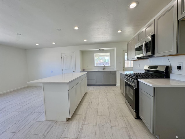 2039 S 11th Ave, Yuma, AZ 85364 - kitchen with stainless steel microwave, gas range, gray cabinets, a sink, and recessed lighting