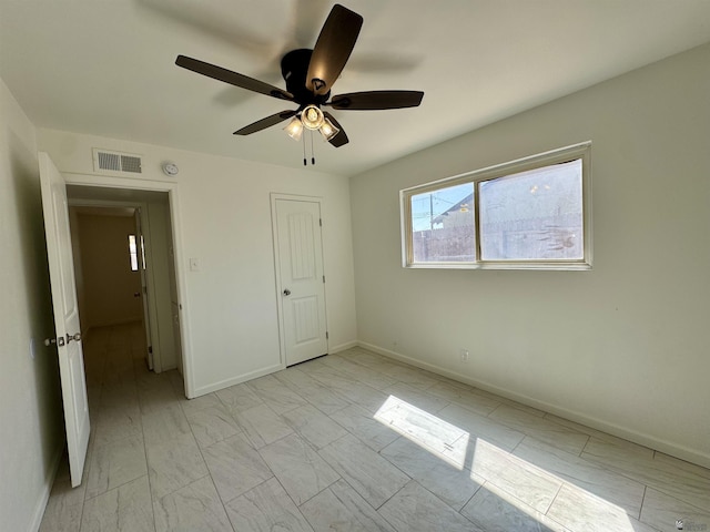 2039 S 11th Ave, Yuma, AZ 85364 - unfurnished bedroom featuring light marble finish floors, a ceiling fan, and baseboards