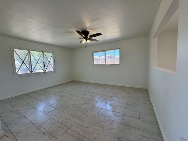 2039 S 11th Ave, Yuma, AZ 85364 - empty room featuring light marble finish flooring, ceiling fan, and baseboards