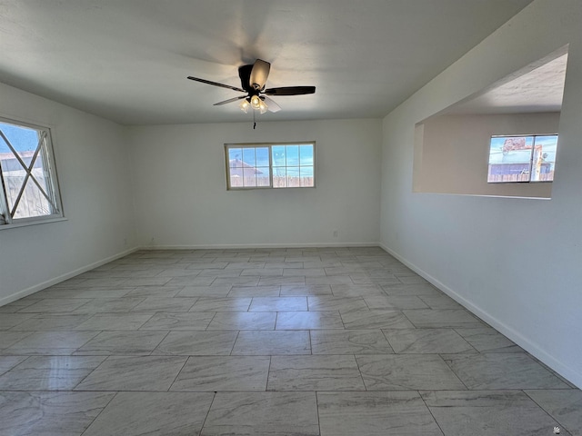 2039 S 11th Ave, Yuma, AZ 85364 - empty room featuring light marble finish floors, a ceiling fan, and baseboards