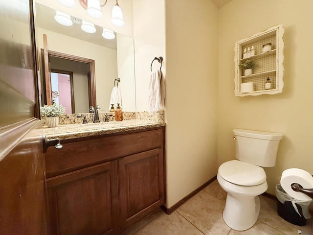 half bathroom with tile patterned flooring, toilet, baseboards, and vanity