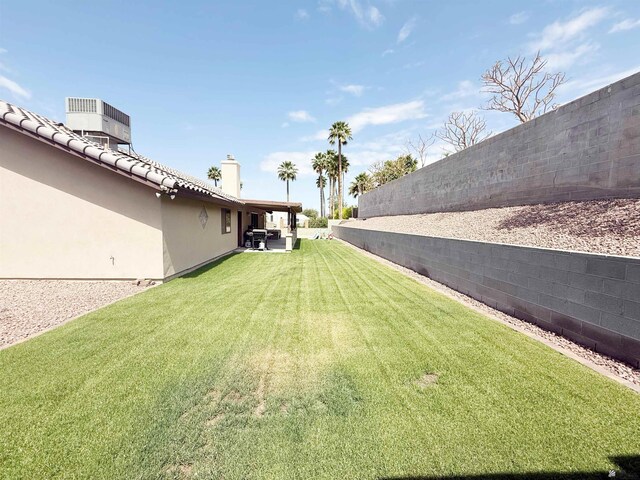 view of yard with central air condition unit, fence, and a patio area