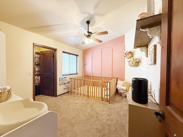 bedroom featuring vaulted ceiling, light colored carpet, ceiling fan, and a crib