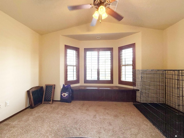 carpeted empty room with a wealth of natural light, lofted ceiling, and ceiling fan