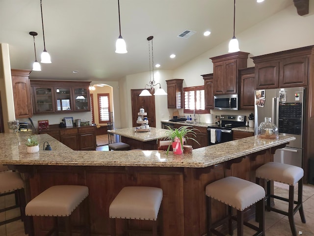 1404 W Parkway Dr, Yuma, AZ 85364 - kitchen with stainless steel appliances, lofted ceiling, healthy amount of natural light, arched walkways, and a breakfast bar