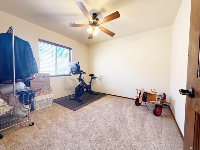 exercise room with a ceiling fan, baseboards, visible vents, and carpet
