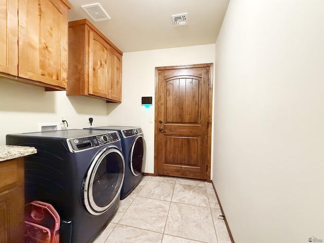 washroom with cabinet space, washing machine and clothes dryer, visible vents, and baseboards