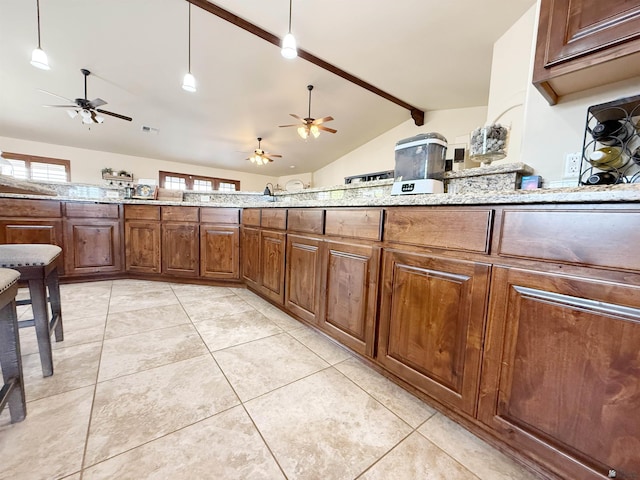 kitchen with light stone counters, light tile patterned flooring, ceiling fan, and vaulted ceiling with beams