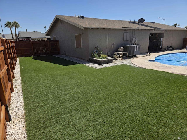 1904 E 26th Pl, Yuma, AZ 85365 - back of property with stucco siding, central AC unit, roof with shingles, and a patio area